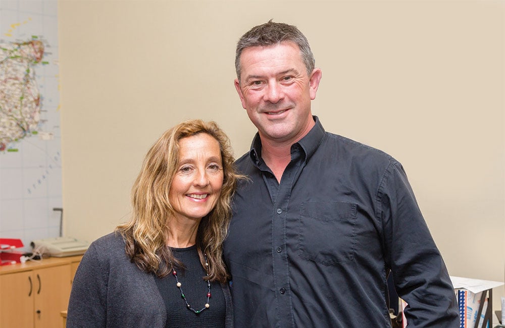 Two Drain Doctor franchisees smiling, looking at the camera in an office